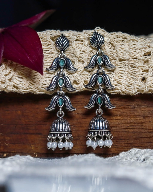 Silver-toned oxidised three tiered jhumka style earrings with blue stones